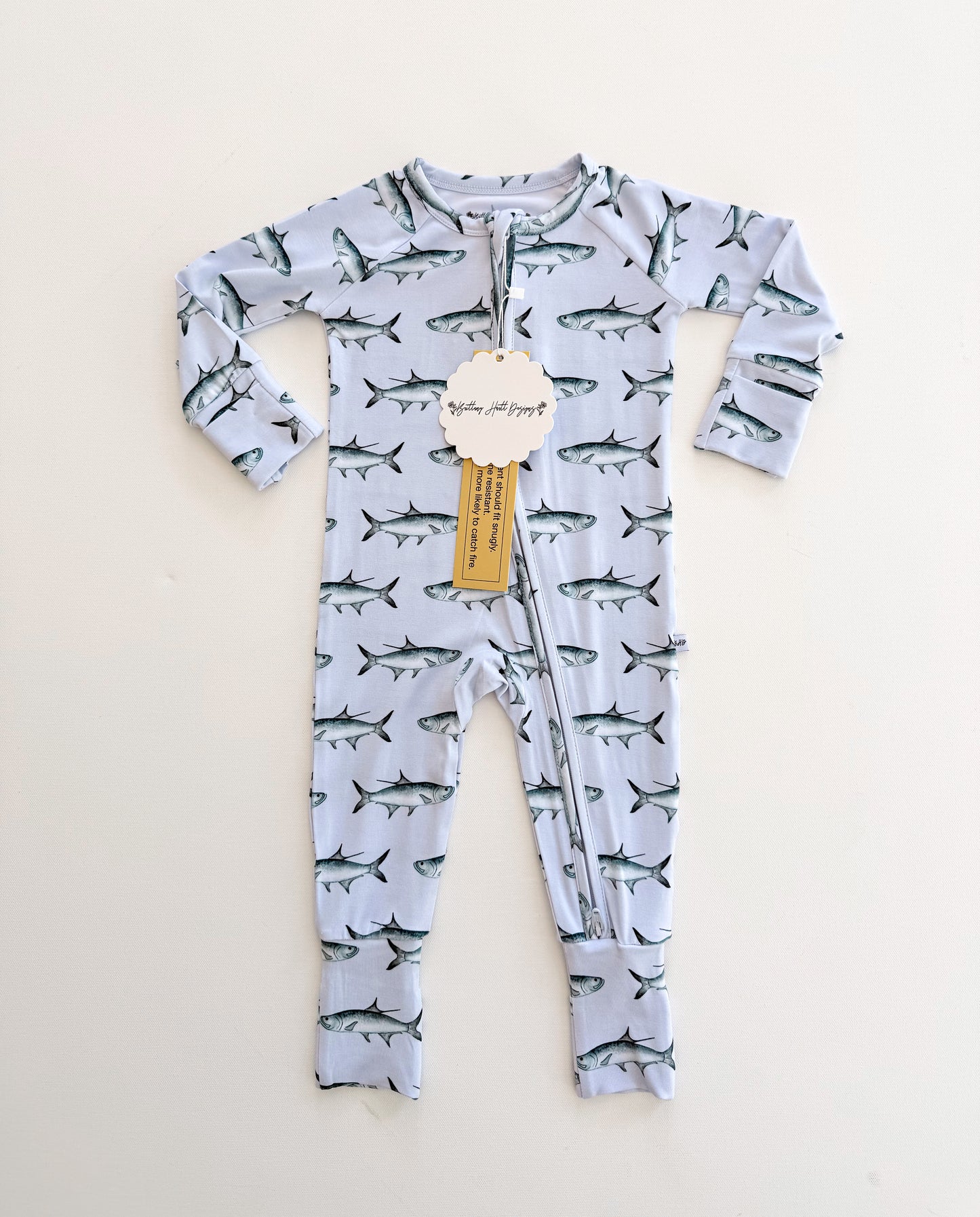 Baby onesie with tarpon pattern on a light blue background