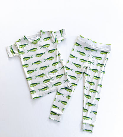 A two-piece children's pajama set featuring a short-sleeve top and matching leggings, both printed with a green and yellow marlin fish pattern on a white background, laid flat on a white surface.