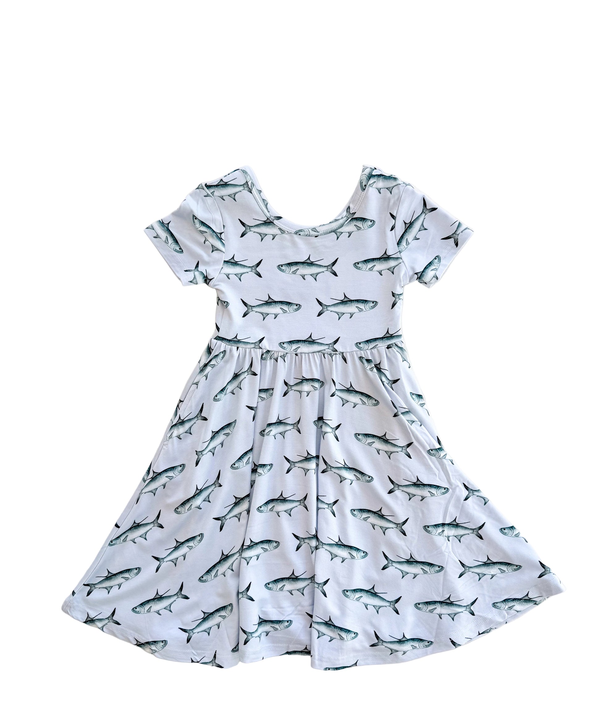 Flat lay of short sleeved, twirl dress with light blue background and blue tarpon and pockets