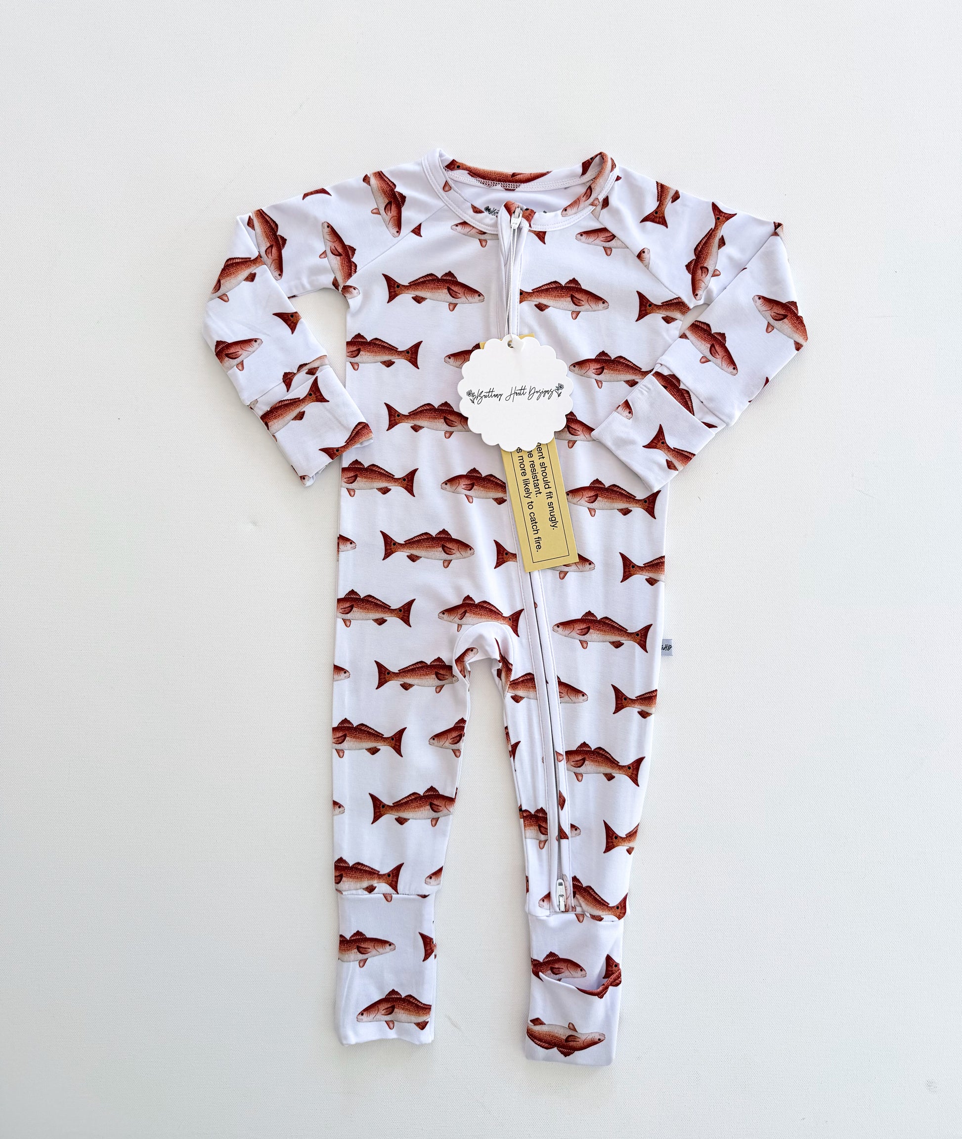 Baby onesie with a redfish pattern on a white background