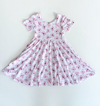 White dress with pink floral pattern on a white background