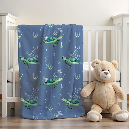 Blue blanket with turtle pattern next to a teddy bear in a crib.