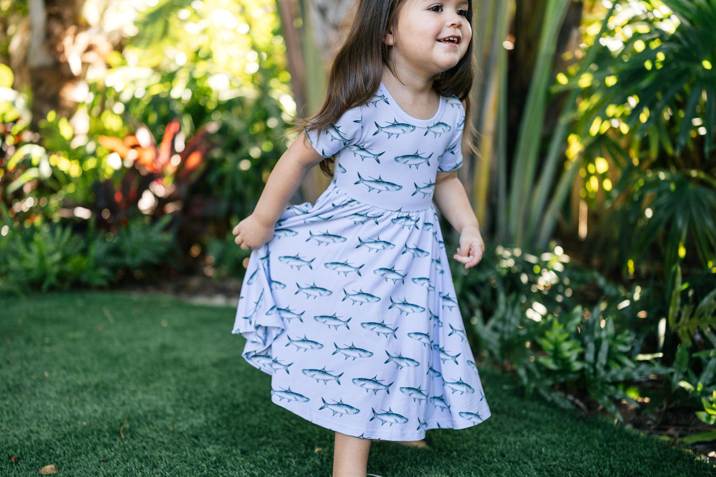 Little girl running in the tarpon seaside dress