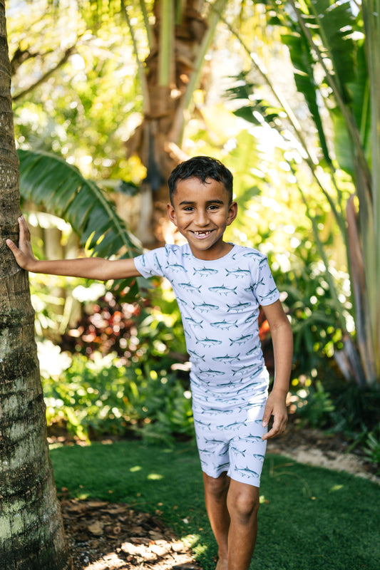 child leaning on a tree wearing tarpon two piece pajama set