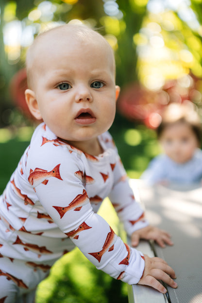 Baby wearing a zippy with redfish pattern outdoors