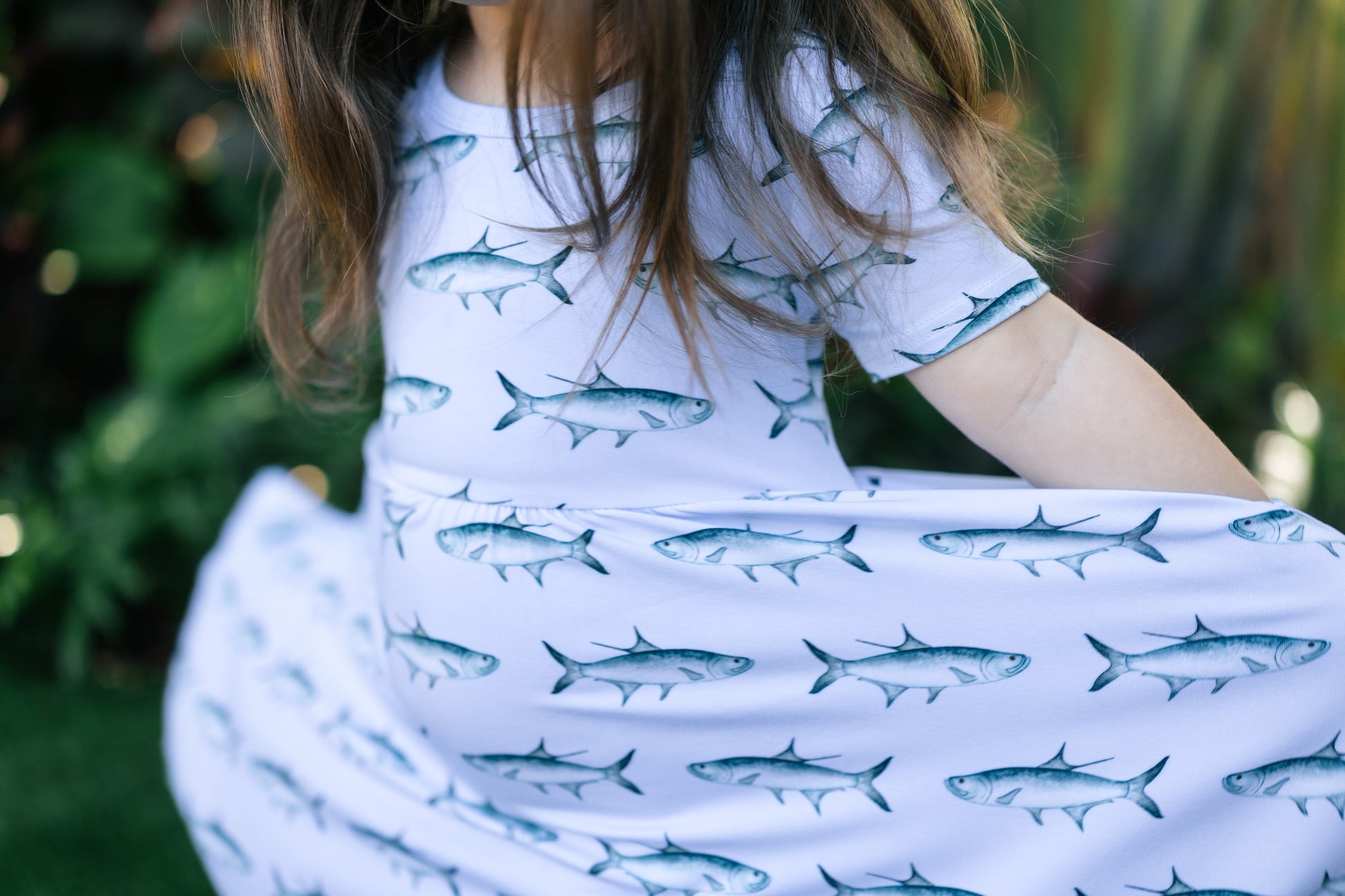 close up of a little girl stretching the tarpon seaside dress