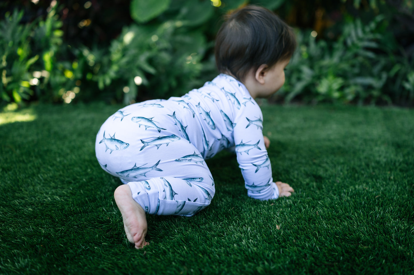baby crawling on turff in a tarpon zippy