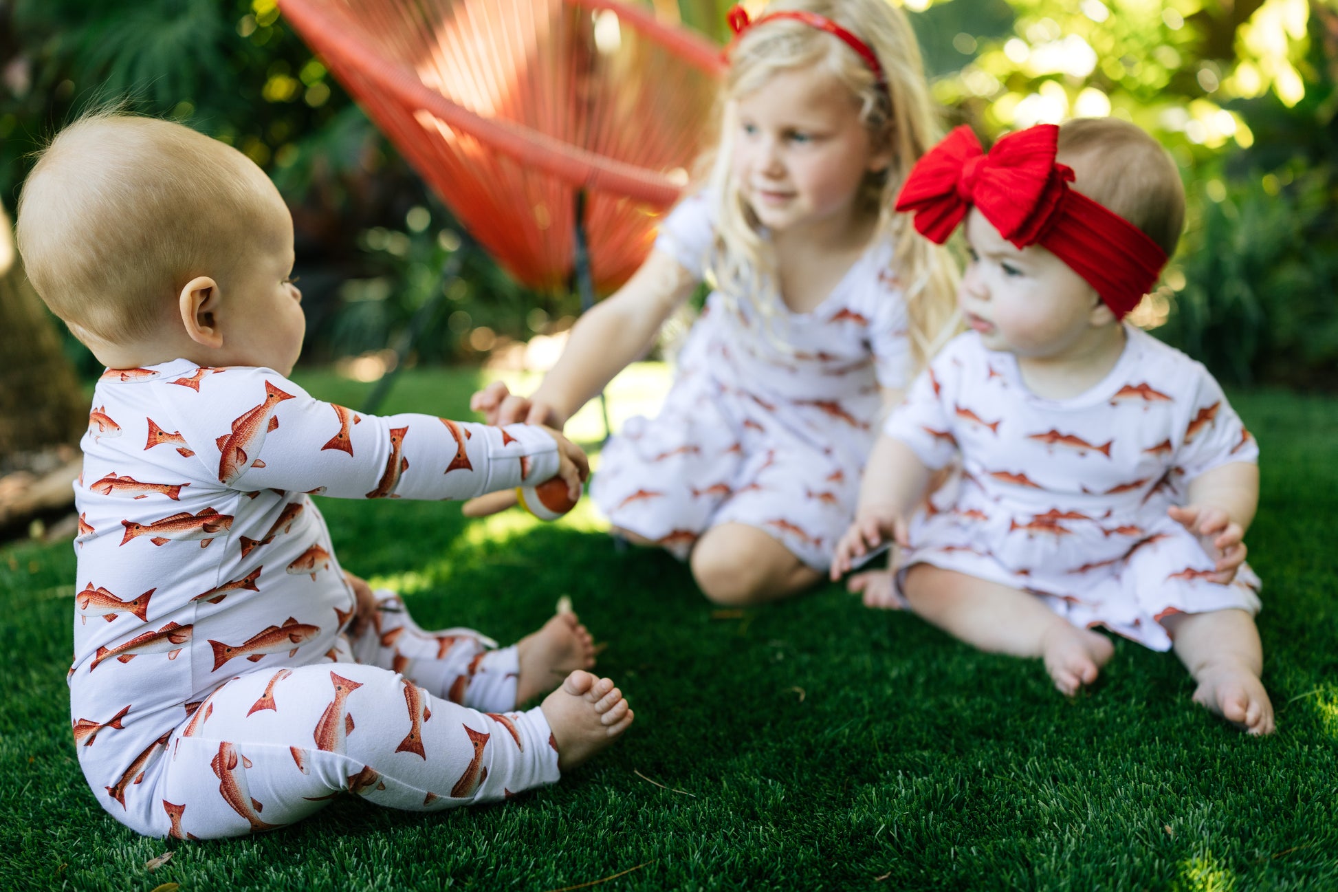group of children in matching redfish outfits playing in the turf