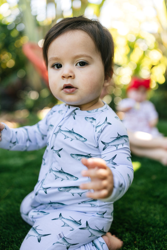 Little boy wearing the tarpon zippy sitting on his knees outdoors