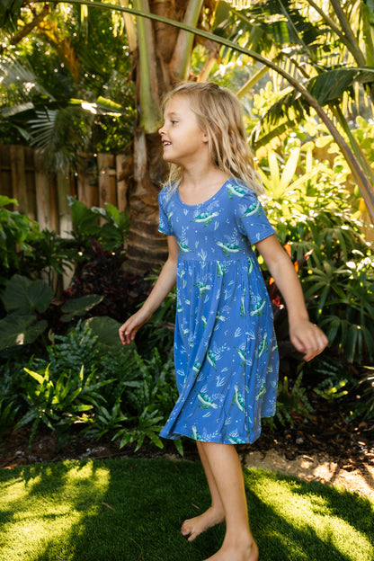 Young girl spinning in sea turtle seaside dress