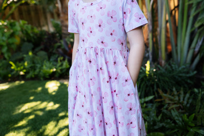 closeup of the riverside blooms print worn by a little girl with hands in her pockets