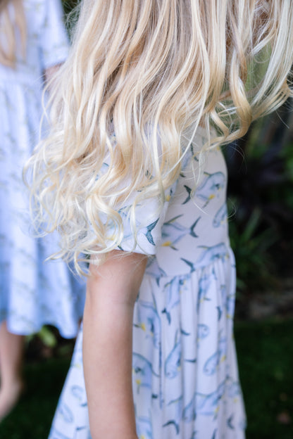 closeup of young girl wearing a permit seaside twirl dress with a tropical background
