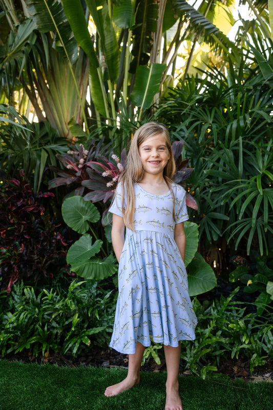 Young girl modeling snook seaside dress with tropical background