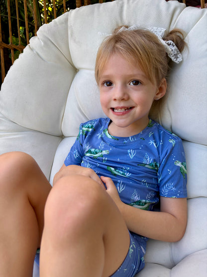 Customer provided photo of a little girl wearing the blue short sleeve pajamas with sea turtles