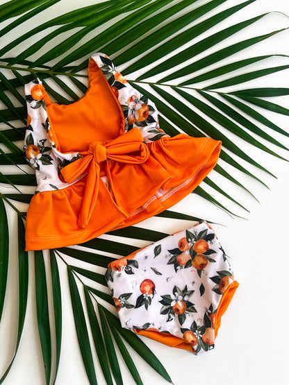 Orange and floral bikini set on a leafy background