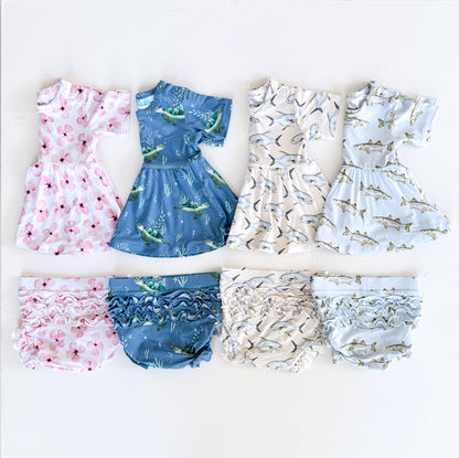 Set of children's Peplum Sets with various patterns on a white background