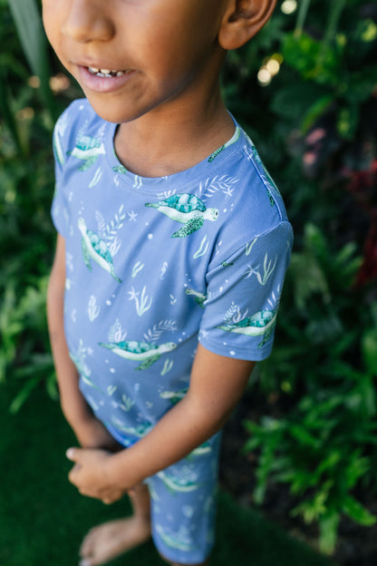 Close-up of little boy wearing blue pajamas with sea turtles