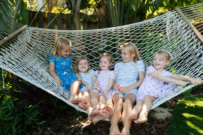 Group of kids wearing all different pajamas, sitting in a hammock